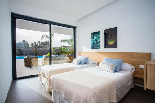 特吉塞Villa Macán的卧室内的两张床,享有游泳池的景色