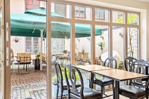 马尔默皇家贝斯特韦斯特酒店的一个带桌椅和遮阳伞的庭院