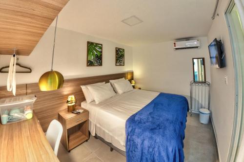 嘎林海斯港Flats Angatu Porto de Galinhas PE的一间卧室配有一张带蓝色毯子的床