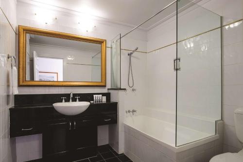 布里斯班布里斯班安扎克广场阿迪纳公寓式酒店的一间带水槽和玻璃淋浴的浴室