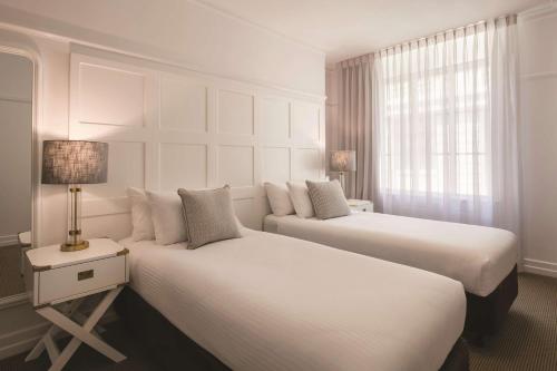 布里斯班布里斯班安扎克广场阿迪纳公寓式酒店的酒店客房设有两张床和窗户。