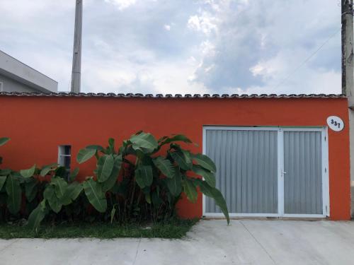 伯迪亚哥Pousada da Sú的一座橙色的建筑,有门和植物