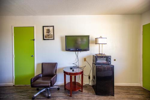 斯威特沃特Marifah Inn Sweetwater的配有电视、椅子和桌子的房间