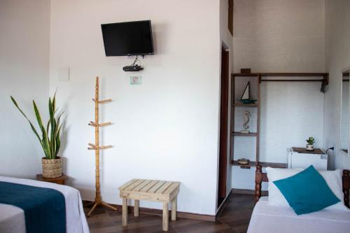 阿布拉奥Suites Casa Azul-Vila do Abraão- conforto, limpeza, ótima localização的客厅配有沙发和墙上的电视