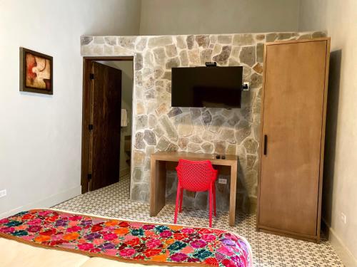 Cuatrociénegas de CarranzaHotel Casa Nodin的一间设有桌子、红椅子和电视的房间