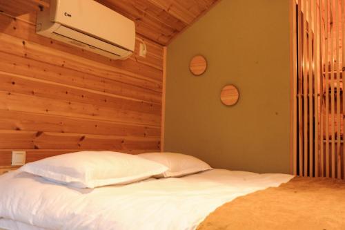 安布罗劳里Jvarisa Glamping的卧室配有白色的床和木墙