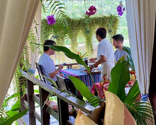 拜县帕拉维达拜度假酒店的坐在花园里桌子上的一群人