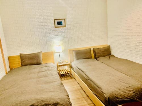 横滨YokohamaKannai HouseBar的卧室内两张并排的床