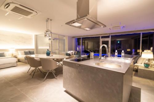 宫古岛Ronsard Resort IRABU的厨房以及带水槽和沙发的客厅。