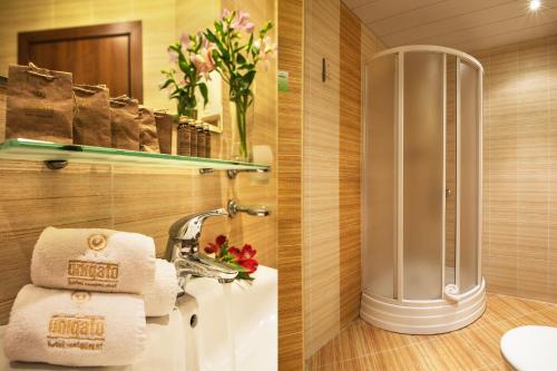 旧扎戈拉Uniqato Hotel的带淋浴和毛巾水槽的浴室