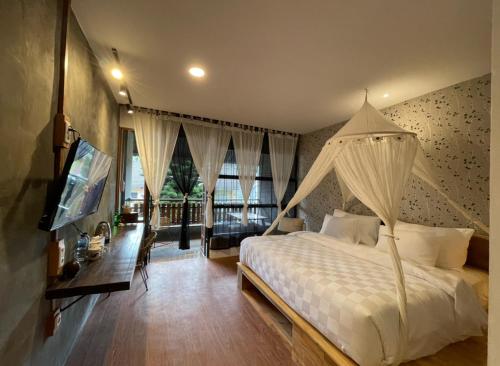 不拉士打宜卡朗乌鲁酒店的卧室配有白色的床和电视。