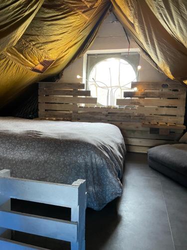 FloreffeCasawellness nuit insolite avec jacuzzi的帐篷内的卧室,配有一张床和一个窗户