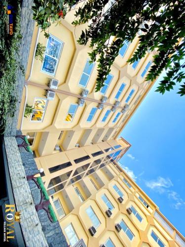 达累斯萨拉姆Royal Village Hotel的黄色建筑的侧面设有窗户