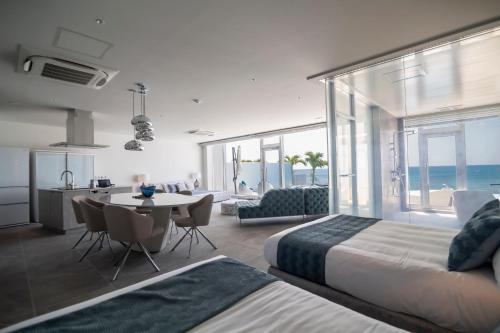 宫古岛Ronsard Resort IRABU的一间带两张床和一张桌子的卧室以及一间厨房