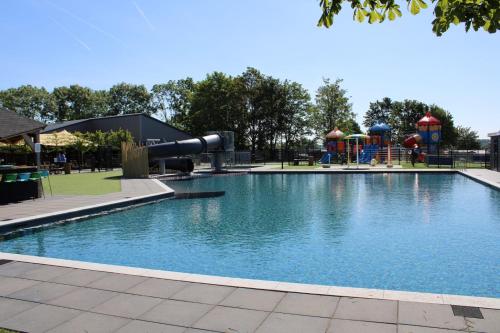 LathumChalet Familienzeit的公园内的游泳池,带游乐场