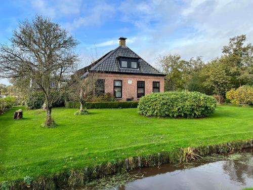 威塞勒海德Het Wylde Pad - Let’s go Wylde!的河边草地庭院上的砖房