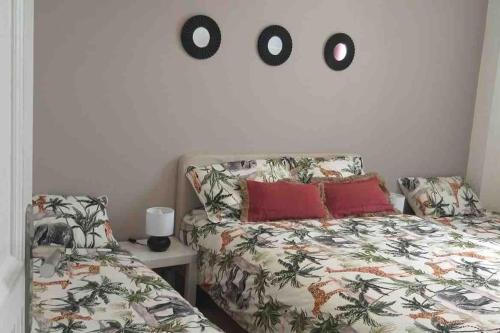 博比尼La petite maison的一间卧室配有一张床,墙上挂着两把钟