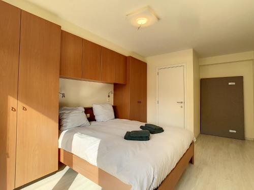 东代恩凯尔克Residentie Laurence - 'SEAGIRL'的一间卧室配有一张带木制橱柜的大床