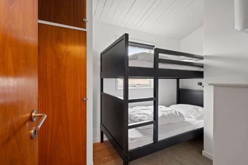 BrenderupRemarkable 2-Bed Beach House 12J的一间卧室配有双层床和一扇门