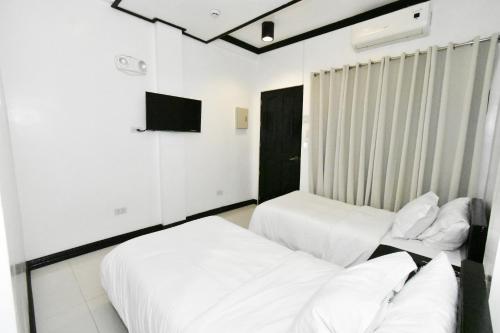 爱妮岛金丝燕酒店 的白色墙壁客房的两张床