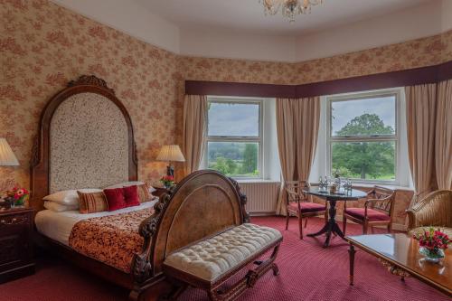 金斯考特卡布拉城堡酒店的卧室配有一张床和一张桌子及椅子