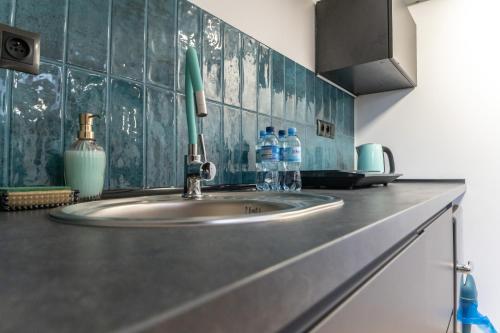 拉多姆Uroczy, przytulny apartament poddasze的厨房水槽和柜台上的2瓶水