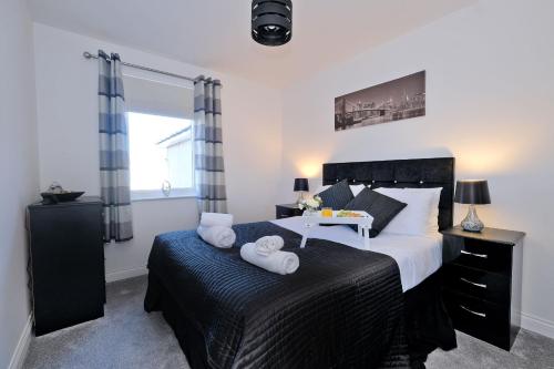 阿伯丁Orange Apartments Beechgrove Gardens的一间卧室配有一张大床和毛巾