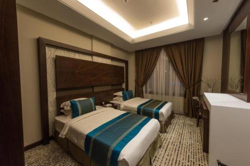 利雅德Voyage Hotel & Suites的酒店客房设有两张床和盥洗盆