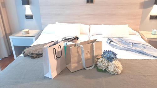 马里亚诺努埃瓦广场酒店的睡床上两个购物袋