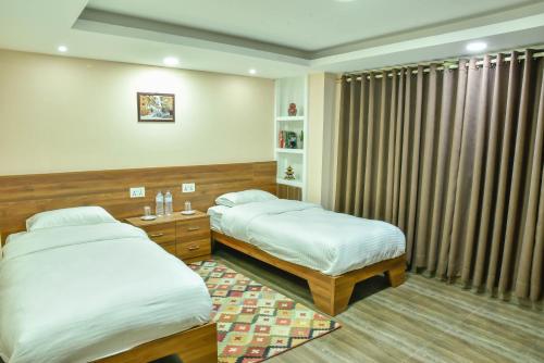 帕坦King Size Bedroom Vacation Home near Patan Durbar的一间卧室设有两张床,窗户配有窗帘