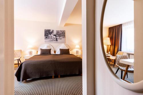 巴特弗兰肯豪森图林根霍夫酒店的酒店客房,配有床和镜子