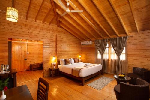 马迪凯里The Porcupine Castle Resort的木制客房内的一间卧室,配有一张床