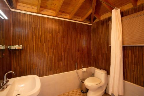 马迪凯里The Porcupine Castle Resort的浴室配有卫生间、浴缸和水槽。