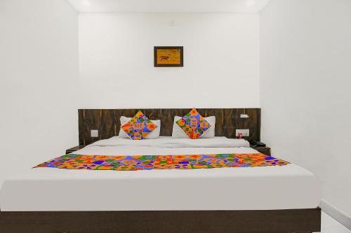 博帕尔FabHotel HTC的一间卧室配有一张大床和色彩缤纷的被子