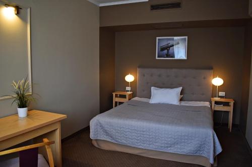 萨图马雷Vila Camino的一间卧室配有一张带两张桌子和两盏灯的床。