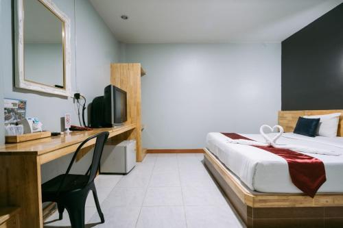 武里南金塔娜度假酒店的一间卧室配有一张床和一张书桌