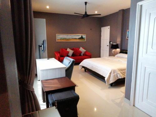 功孟海滩Klong Muang Beach Apartment的一间卧室配有一张床和一张红色的沙发
