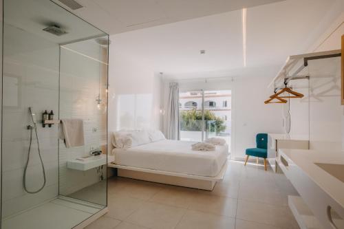 卡兰博希Lago Resort Menorca - Casas del Lago Adults Only的白色卧室设有床铺和玻璃淋浴间