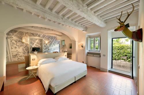 基安蒂格雷夫Casolese di Vignamaggio的卧室配有一张床,墙上挂着鹿头