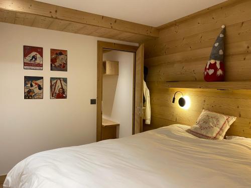 蒙热内夫尔Le Chaberton, rénové en 2021, pied des pistes et spa的木制客房内的一间卧室,配有一张床