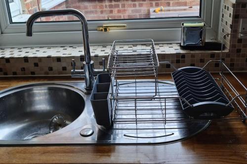 KintburyGorgeous 2 bedroom Kintbury cottage的厨房水槽旁设有碗碟干燥架