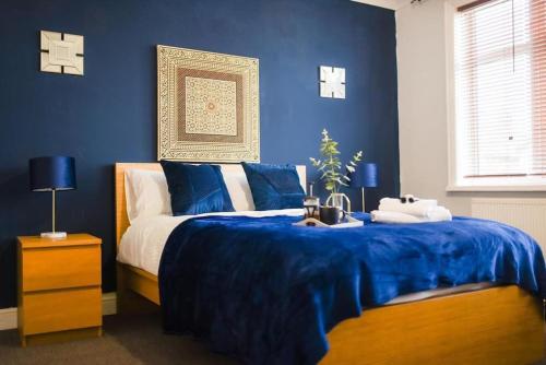 南安普敦Beautiful Large 4 Bedrooms house in central Southampton的蓝色卧室,配有一张带蓝色毯子的床