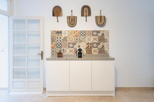 EsteponaCasa Blanca的厨房配有白色橱柜和瓷砖墙。