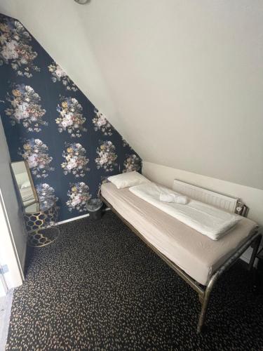 鹿特丹瑟斯比耶谢尔酒店的小房间设有一张蓝色墙壁的床