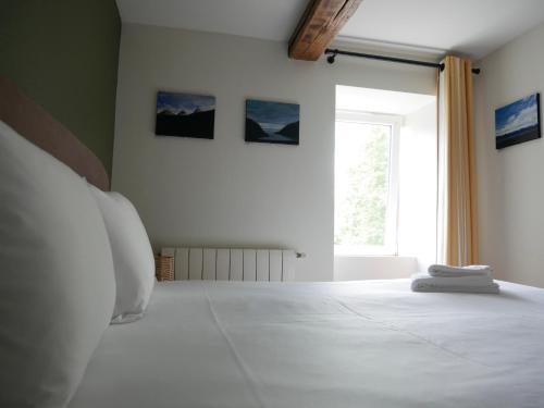亚斯凯恩Auberge Trabenia的卧室配有一张大白色床和窗户