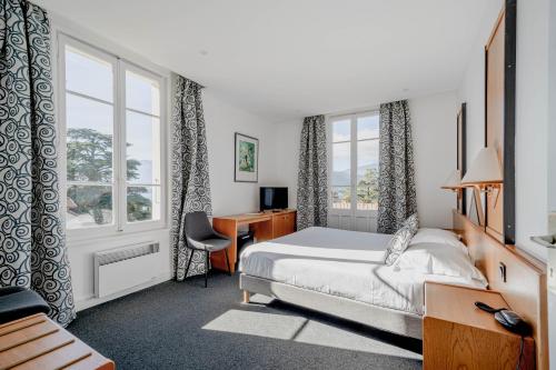塔卢瓦尔杜拉克酒店的一间卧室配有一张床、一张书桌和窗户。