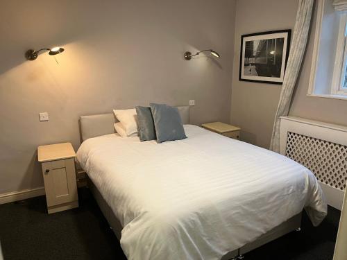 圣比斯Lulus的一间卧室配有带白色床单和蓝色枕头的床。