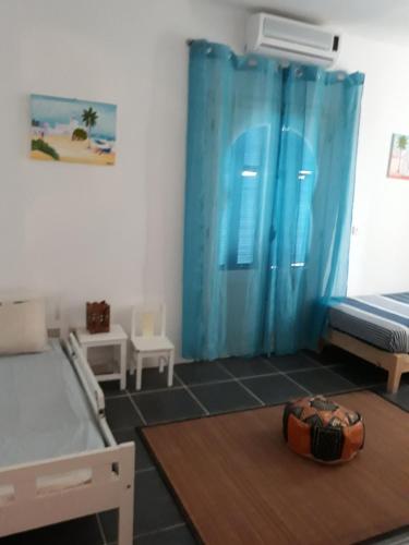 MezraneDar Chick Yahia Ile De Djerba的一间卧室配有两张床和蓝色窗帘
