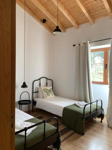 埃斯特雷莫斯Herdade Da Maridona - Agroturismo的一间卧室设有两张床和窗户。