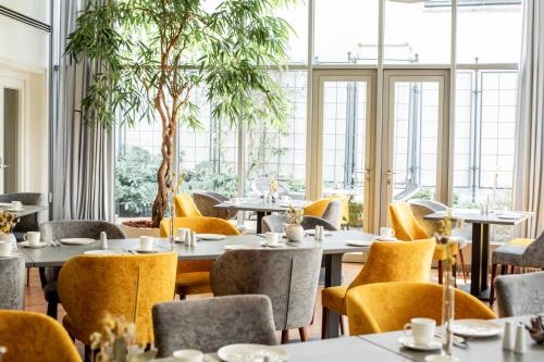 班贝格Altstadthotel Messerschmitt的餐厅设有桌椅和窗户。